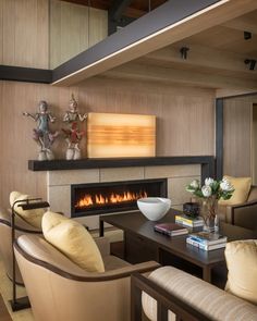 a living room filled with furniture and a fire place next to a wall mounted tv