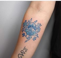 a woman's arm with blue flowers and the word love tattooed on her left arm