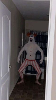 a man dressed as a clown standing in the hallway