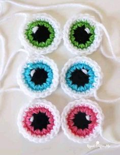 four crocheted eyeballs sitting on top of a table