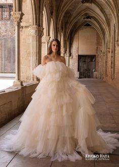 a woman in a wedding dress is posing for the camera