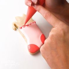 a person is decorating a cookie with icing