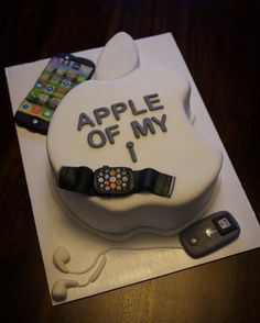 an apple cake with the words apple of my life on it and two cell phones