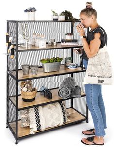 a woman standing in front of a shelf holding a bag