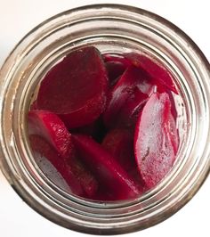 a jar filled with beets sitting on top of a table