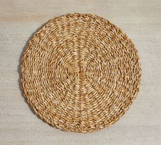 a round woven placemat on a wooden surface