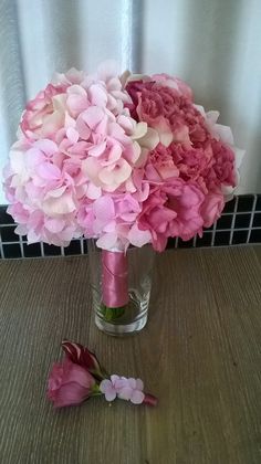 a vase filled with pink flowers on top of a wooden table