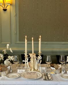 a table set with candles and place settings