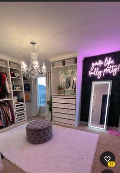 a bedroom with white carpet, chandelier and purple lights on the wall above it