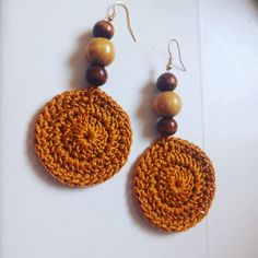 a pair of earrings with wooden beads on them