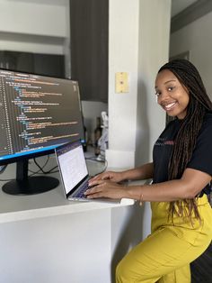 a woman sitting in front of a computer monitor