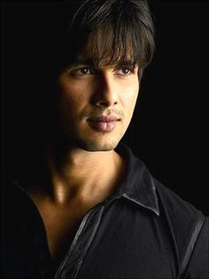 a close up of a person wearing a black shirt and looking at the camera with a serious look on his face