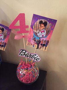 a table topped with cake pops covered in pink frosting and sprinkles