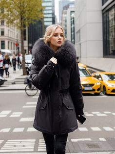 Fashionable and fierce, this coat is designed for those who want to stay warm without compromising on style. The soft faux fur-lined hood not only offers extra protection from the cold but also elevates the overall look of the coat. The cinched waistline provides a tailored, feminine fit, while the sleek front closure keeps the coat modern and functional. Ideal for both casual and formal settings, this coat can be styled with leather pants, jeans, or a chic dress, making it a versatile addition Winter Faux Fur Long Coat, Warm Faux Fur Outerwear For Winter, Warm Faux Fur Winter Outerwear, Cold Weather Long Coat With Faux Fur Lining, Fall Faux Fur Coat With Detachable Hood, Long Coat With Faux Fur Lining For Cold Weather, Winter Faux Fur Coat With Fleece Lining, Winter Faux Fur Outerwear With Lining, Faux Fur Lined Outerwear For Winter