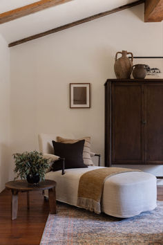 a living room filled with furniture and a wooden table next to a dresser on top of a hard wood floor