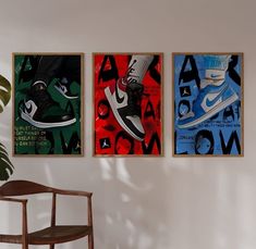 three framed posters hang on the wall above a chair in a room with a plant