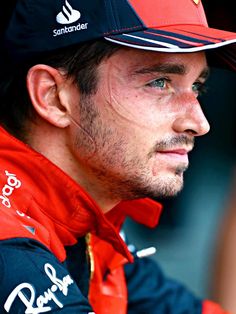 a close up of a person wearing a red and black uniform with a hat on