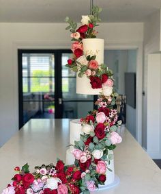 two tiered wedding cake with flowers on the top and bottom, sitting on a table