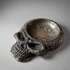 a silver bowl with two skulls on it