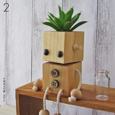 a wooden robot planter sitting on top of a table