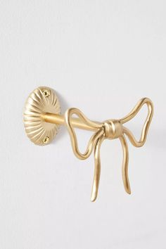 a gold bow tie hook on a white wall