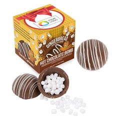 three chocolate covered candies in front of a box with white marshmallows