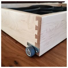 a close up of a piece of wood on a wooden floor with two metal rollers