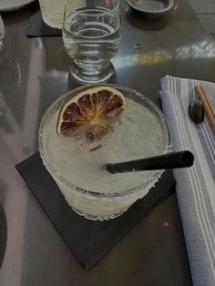 a table with glasses, plates and utensils on it that have blood orange slices in them