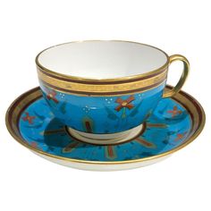 a tea cup and saucer with gold trimmings