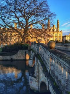 an old stone bridge over a river with buildings in the background