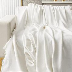 a white couch with a blanket on top of it