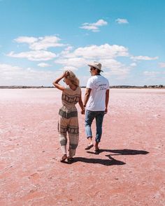 a man and woman are walking in the desert