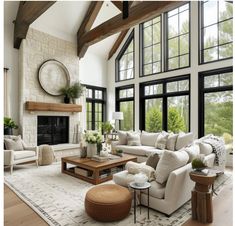 a living room filled with lots of furniture next to large windows and a fire place