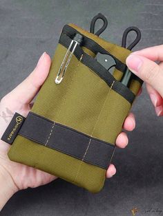 a hand holding a small pouch with scissors in it