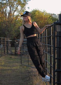 a woman leaning against a fence with her hand on the rail