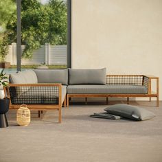 a couch sitting on top of a carpet covered floor next to a table and potted plant