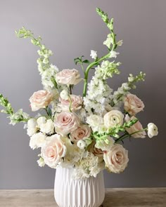 a vase filled with lots of white and pink flowers