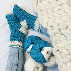 two balls of yarn, one blue and one white are laying next to each other