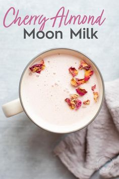 an overhead view of a cup of cherry almond moon milk with rose petals on top