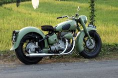 a green motorcycle is parked on the side of the road