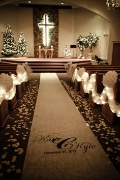 the aisle is decorated with white flowers and angel wings