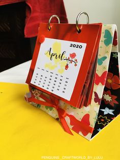 the calendar is on top of two small bags that are sitting on a yellow table