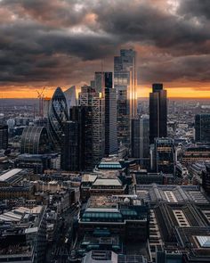 an aerial view of the london skyline at sunset with clouds in the sky and buildings on either side