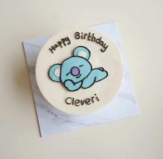 a birthday cake with a blue teddy bear on it's side and the words happy birthday clever