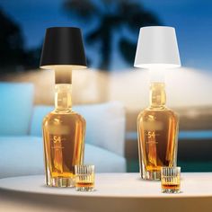 two bottles sitting on top of a table next to a lamp