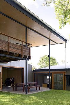 the outside of a house with a covered patio and picnic table