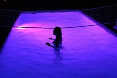 a young child is playing in the water at night