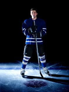 an ice hockey player is posing for the camera