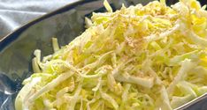 a bowl filled with shredded cabbage on top of a table