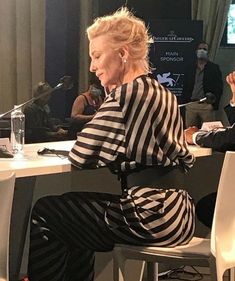 a woman sitting at a table in front of a microphone